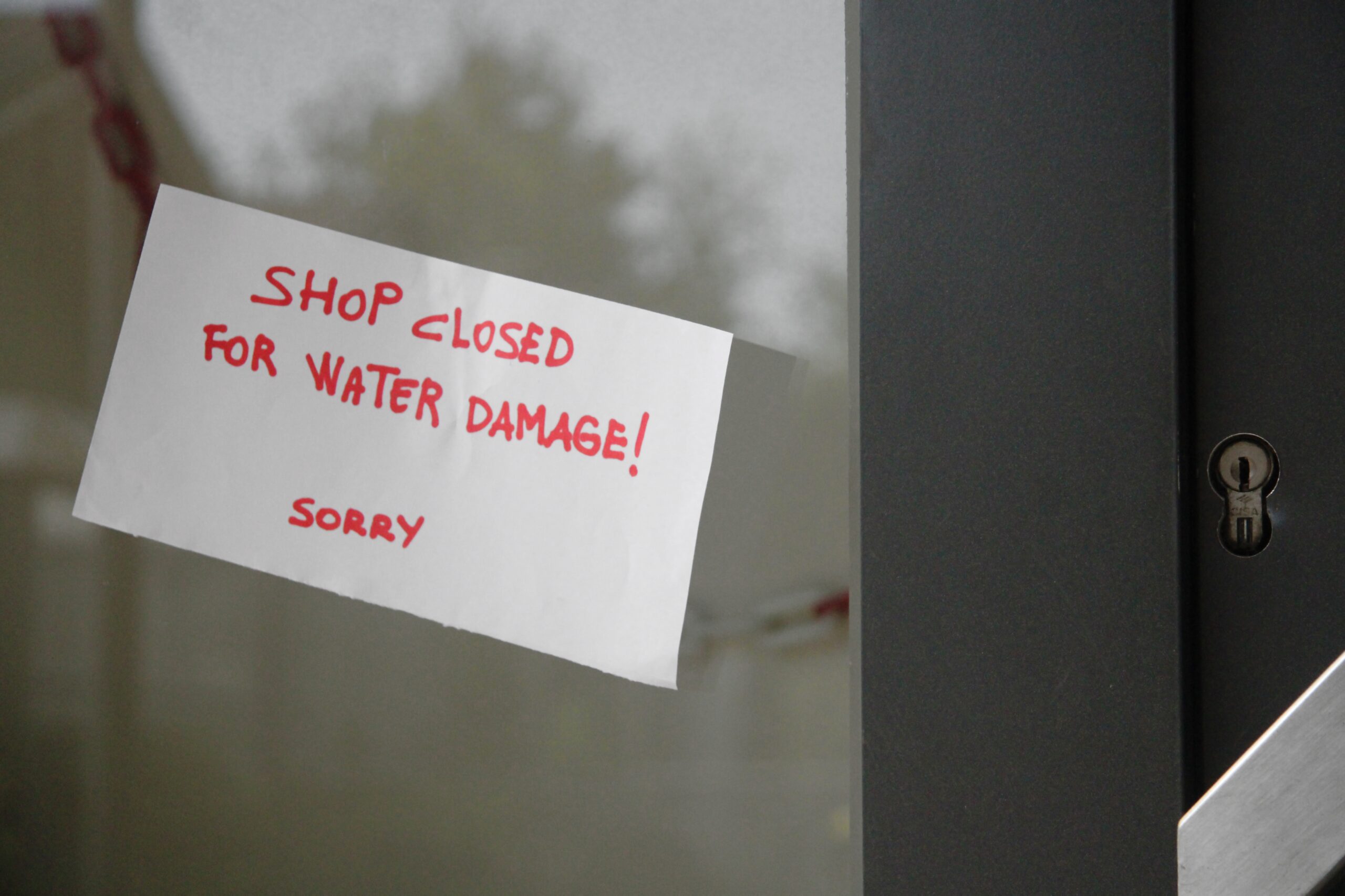 Sign showing shop closed due to water damage.